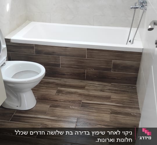 חדר אמבטיה נקי עם אמבטיה ושירותים